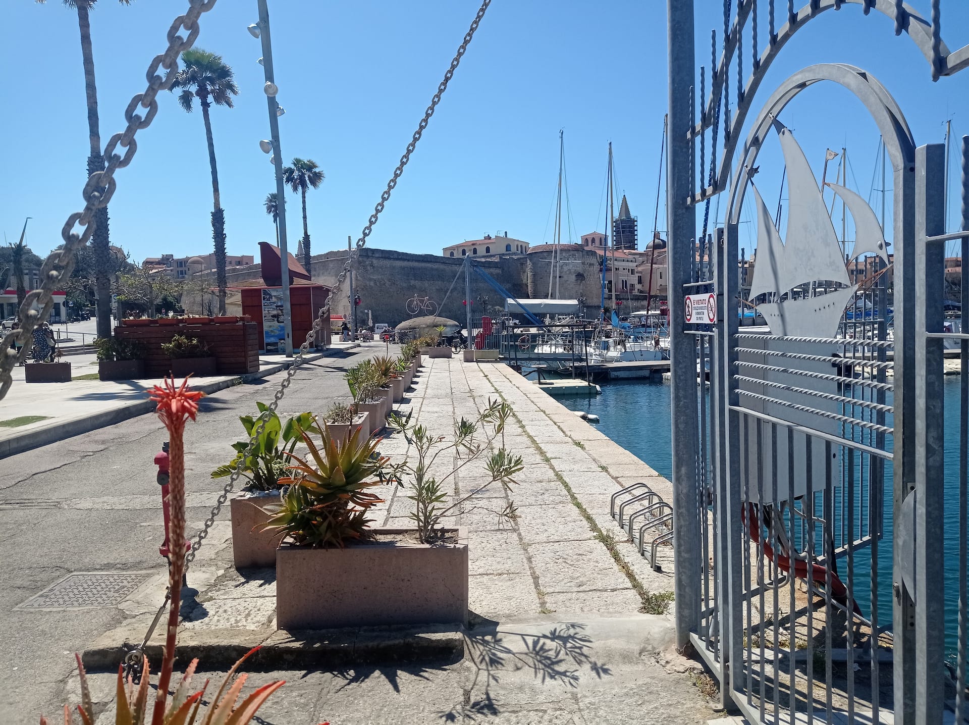 Il lungomare alberato di Alghero con le barche a vela ormeggiate