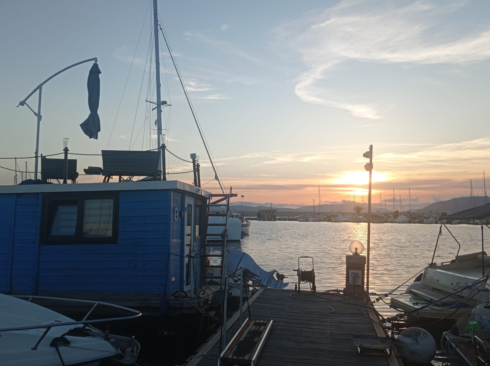 La houseboat blu ormeggiata al pontile al tramonto