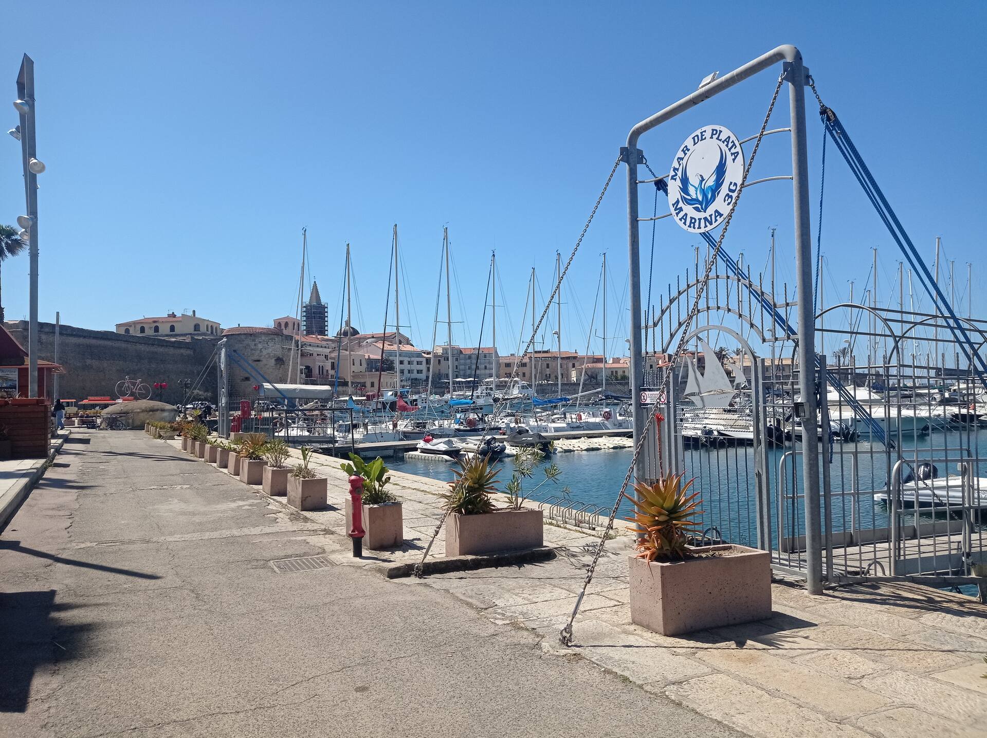 La passeggiata del porto di Alghero con le mura del centro storico